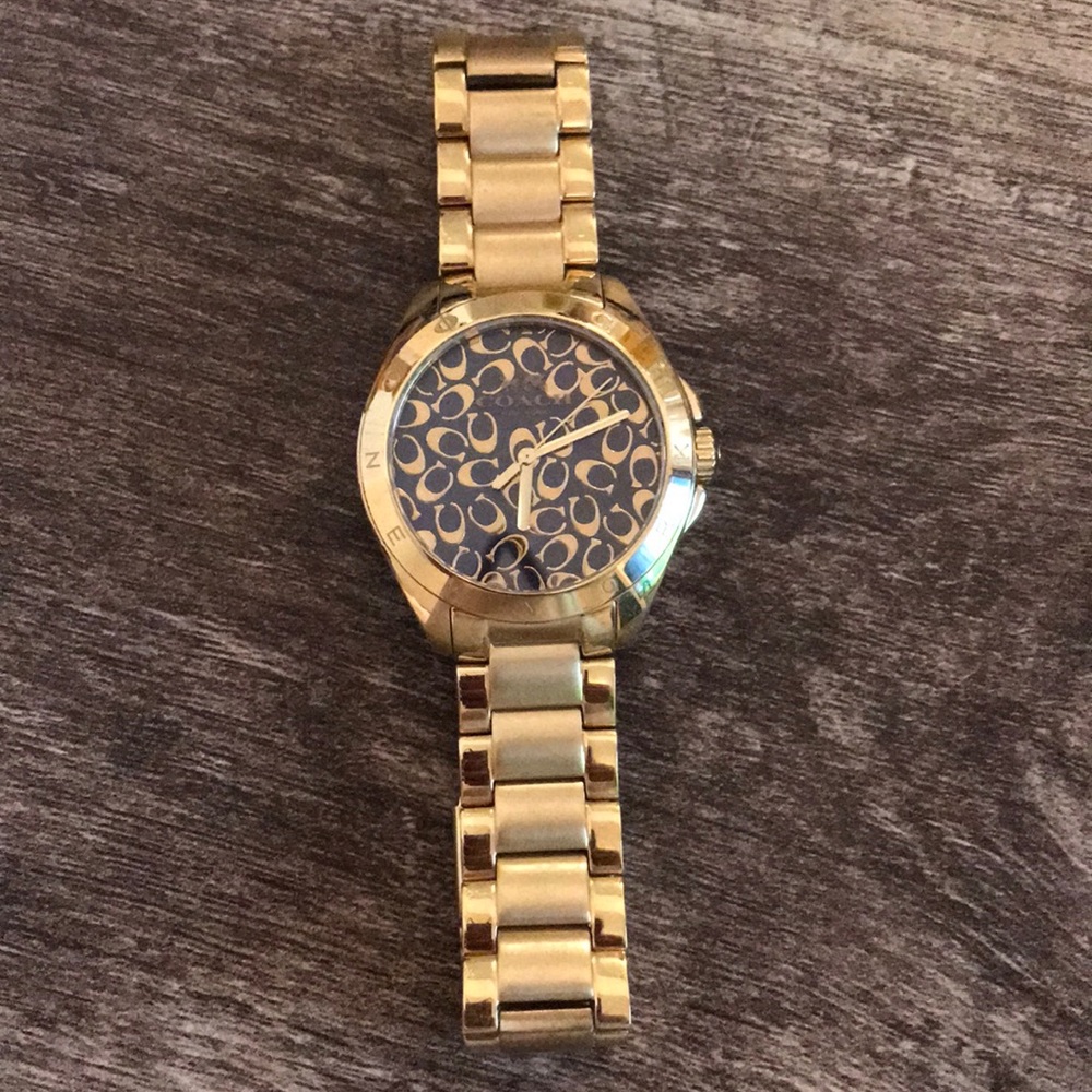 Woman’s Coach gold with black background